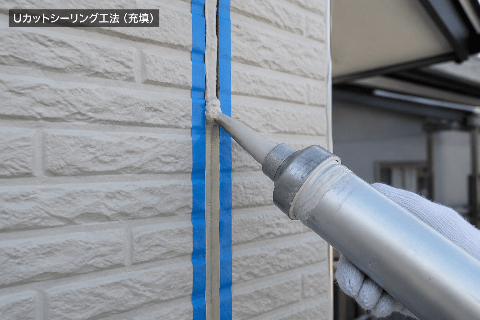 Uカットシーリング工法の施工中写真。U字にカットされた溝と、そこにコーキングを充填している様子がわかるもの]